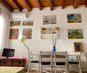 een eetkamer met een tafel en stoelen en foto's aan de muur bij La Casa Del Pittore in Venetië