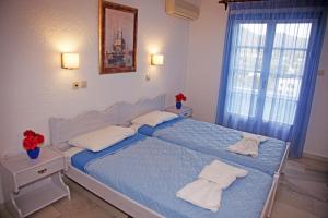 a bedroom with a blue bed with towels on it at St.George Valsamitis in Katapola
