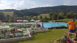 a group of people standing around a swimming pool at Appartement au calme avec terrasse verdoyante entre Annecy et Genève in Villy-le-Pelloux