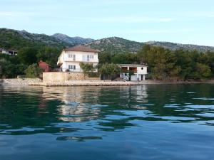 a house on the shore of a body of water at Rooms Ante in Tribanj-Krušćica