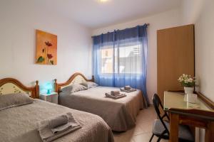 a bedroom with two beds and a table and a window at Armação Beach Residences in Armação de Pêra +100 photos