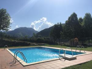 a swimming pool in a yard with mountains in the background at PRECIOSO CHALET JUNTO A POTES CON PISCINA-4 Hab,3 Baños in Ojedo