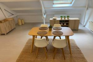 a wooden table and chairs in a room at Moderne loft in historisch pand in Ghent