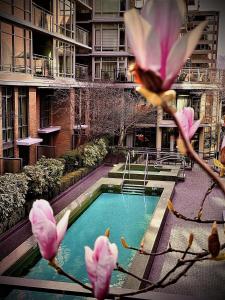 a swimming pool with pink flowers in front of a building at L'Hermitage Hotel in Vancouver