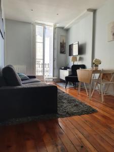 a living room with a couch and a table at Le triangle d or in Bordeaux