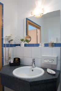 a bathroom with a sink and a mirror at Saar Galerie in Saarburg