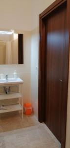 a bathroom with a sink and a wooden door at Sant'Ermete in Matino