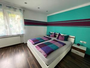 een slaapkamer met een groot bed met paarse en groene muren bij Ferienwohnung Pomaria - 4 Sterne zertifiziert in Pommern