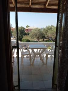 un tavolo e sedie su un patio con tavolo e vista di Joanna studios -apartment ad Acharavi
