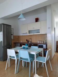 a kitchen with a white table and chairs at Apartmani Darko in Kornić
