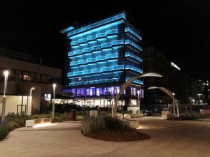 un edificio azul con luces encendidas por la noche en Hotel Diplomatic, en Riccione