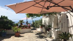 a tan umbrella sitting on the side of a building at Il Paradiso di Giacomo in Erice