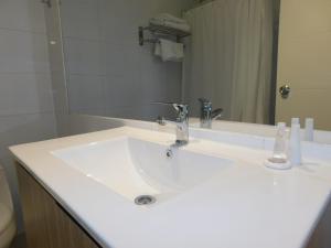uma casa de banho com um lavatório branco e um espelho. em Los Magnolios em Concepción