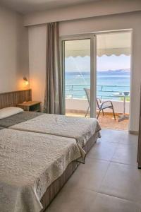 een slaapkamer met een bed en uitzicht op de oceaan bij Joanna Apartments in Charaki