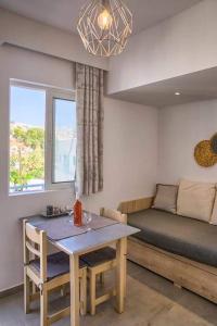 een woonkamer met een bed, een tafel en een bank bij Joanna Apartments in Charaki
