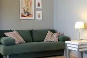 ヘーヴィーズにあるVita Apartmanokのリビングルーム(緑のソファ、枕付)