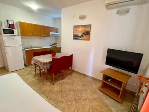 een kleine keuken met een tafel en een televisie bij Apartments Šime in Šibenik