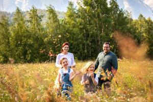 a family walking through a field of tall grass at Appartmenthaus am Moosweg in Seefeld in Tirol