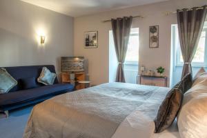 1 dormitorio con 1 cama y 1 sofá azul en Saar Galerie en Saarburg