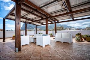 een patio met witte stoelen en een tafel op een dak bij A' Cavalera in San Vito lo Capo