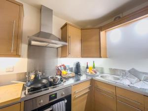 a kitchen with a stove and a sink at Spacious Contractor Flat for Large groups - Private Parking by Tailored Apartments in Cheshunt