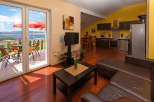 sala de estar con sofá, mesa y cocina en Apartments Villa Americana en Jadranovo