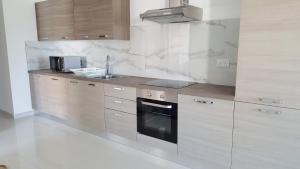 a kitchen with white marble walls and a counter top at The Carobs in Marsaskala