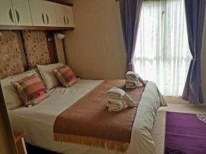 a bedroom with a bed with towels on it at No42 Wild Goose in Dornoch