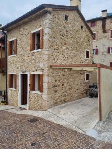 ein Steingebäude mit einem Fahrrad davor in der Unterkunft Giulietta e Romeo in Pove del Grappa
