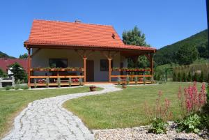 Domek Chmielnik في Pieszyce: منزل صغير بسقف احمر في ساحة