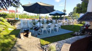 a patio with a table and chairs and an umbrella at Oázis Apartman in Szántód