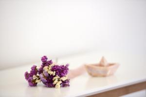 a bunch of purple flowers sitting on a counter at Onar Hydra in Hydra