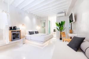 Anastasia's Visage II Stylish Accommodation Rooms City Center Mykonos في مدينة ميكونوس: غرفة بيضاء مع سرير وأريكة