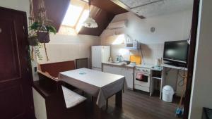 a small kitchen with a table and a small kitchen with a television at Oázis Apartman in Szántód