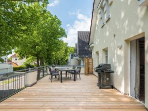 una terraza de madera con mesa y sillas en un edificio en Hideway Lieblingsplatz 200m vom Strand mit Sauna, en Rerik