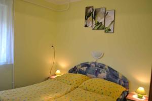 ザラカロシュにあるApartment in Zalakaros/Thermalbad 20663のベッドルーム1室(ランプ2つ、壁に絵2枚付)