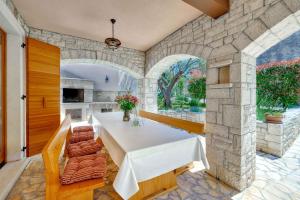 a dining room with a white table and a stone wall at Holiday home in Medulin/Istrien 9006 in Medulin