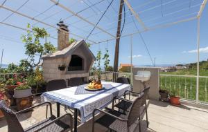 una mesa y sillas en una terraza con una casa de aves en Apartment on the hill overlooking the sea, en Podstrana