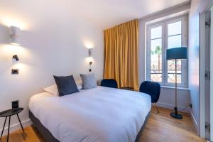 a bedroom with a large white bed and a window at Boutique Hotel Nice Côte d'azur in Nice