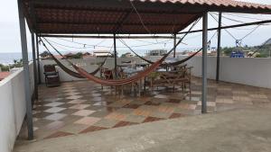 a patio with a hammock on a roof at Casa Blanca Puerto López in Puerto López
