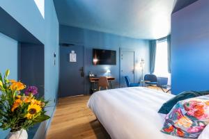 a bedroom with blue walls and a bed with a vase of flowers at Boutique Hotel Nice Côte d'azur in Nice