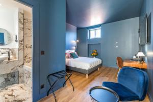 a bedroom with blue walls and a bed and a chair at Boutique Hotel Nice Côte d'azur in Nice