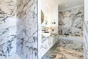 a bathroom with marble walls and a sink and a tub at Boutique Hotel Nice Côte d'azur in Nice