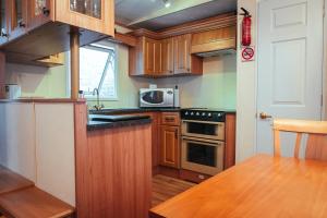 una pequeña cocina con armarios de madera y una mesa. en Aaranmore Mobile Home en Portrush