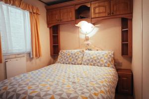 1 dormitorio con 1 cama con luz sobre ella en Aaranmore Mobile Home en Portrush