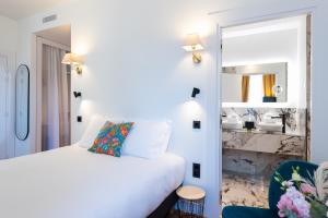 a bedroom with a white bed and a mirror at Boutique Hotel Nice Côte d'azur in Nice
