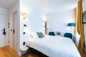 a bedroom with a white bed and blue chairs at Boutique Hotel Nice Côte d'azur in Nice