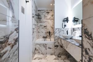 a bathroom with two sinks and marble walls at Boutique Hotel Nice Côte d'azur in Nice