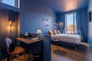 a room with a bed and a desk and a window at Boutique Hotel Nice Côte d'azur in Nice