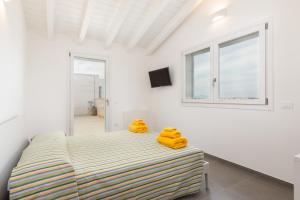 una camera da letto con un letto con asciugamani gialli di Bcolors Rooms, Selargius Is Corrias a Pirri